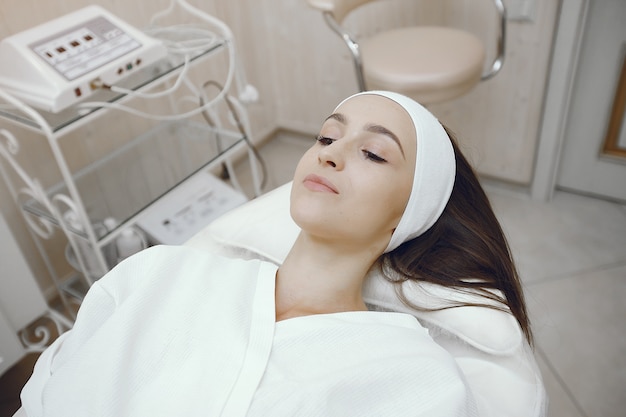 Femme en peignoir blanc dans un studio de cosmétologie