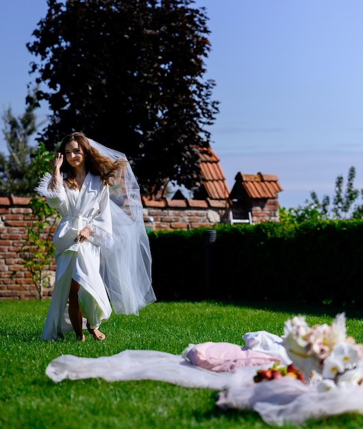 Femme en peignoir posant dans le jardin avec pieds nus