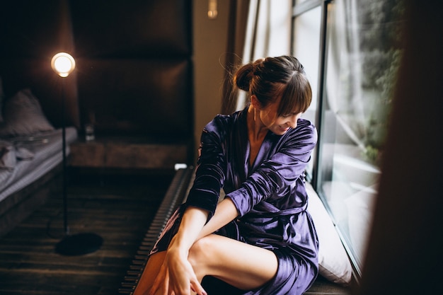 Femme en peignoir violet dans la chambre