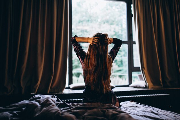 Femme en peignoir violet dans la chambre