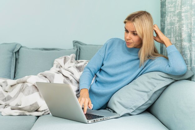 Femme pendant la pandémie travaillant sur un ordinateur portable à la maison