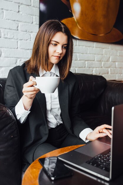 femme pendant la pause, implantation au café avec café et ordinateur portable !