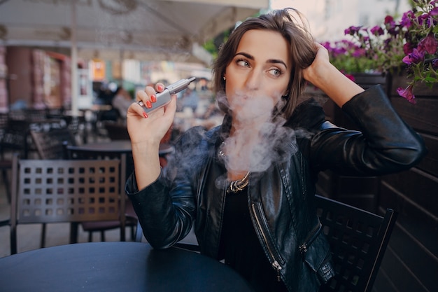 Femme penser avec une cigarette électronique dans la main