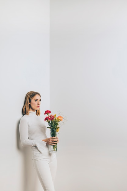 Femme pensif avec bouquet de fleurs