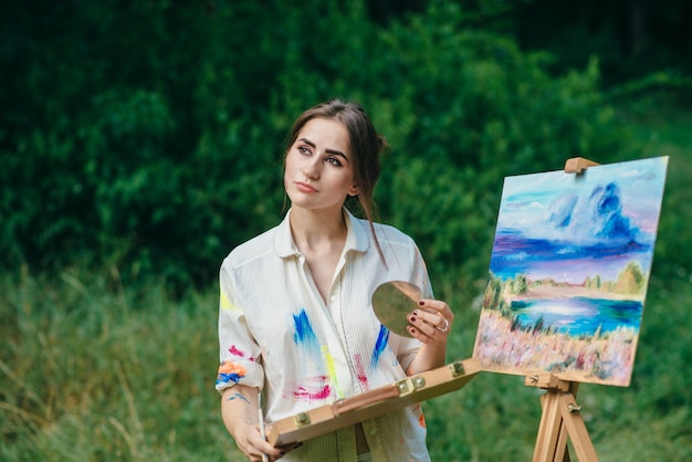 femme pensive avec une boîte de peintures