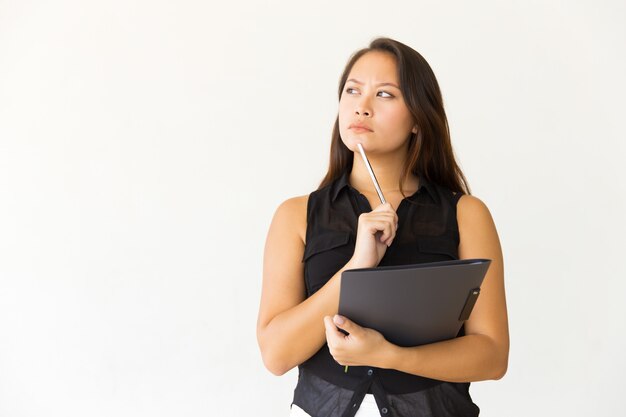 Femme pensive avec dossier et stylo