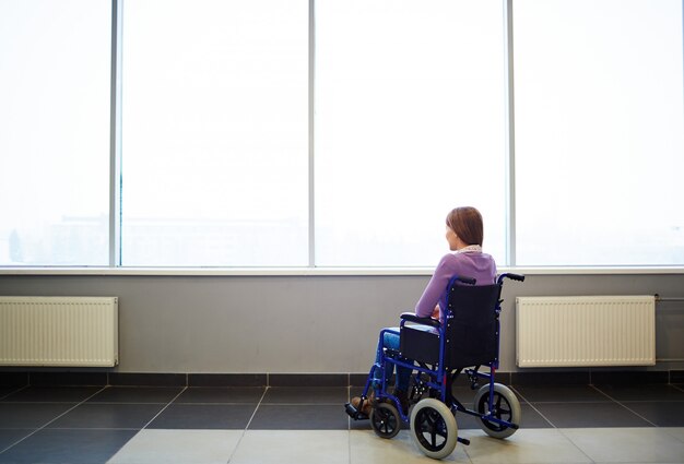 Femme pensive en fauteuil roulant