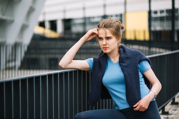 Femme pensive posant à la main courante