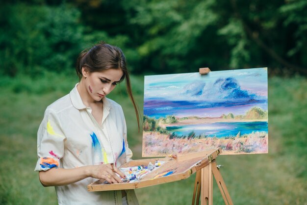 femme pensive regardant une boîte de peintures