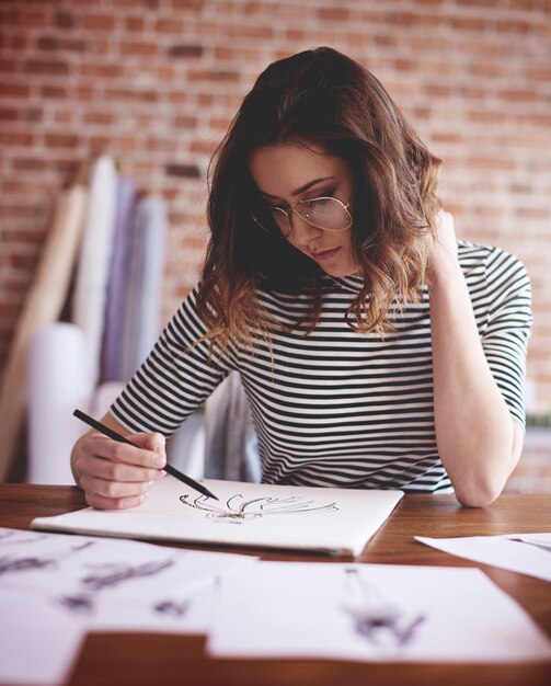 Femme pensive travaillant sur un projet important