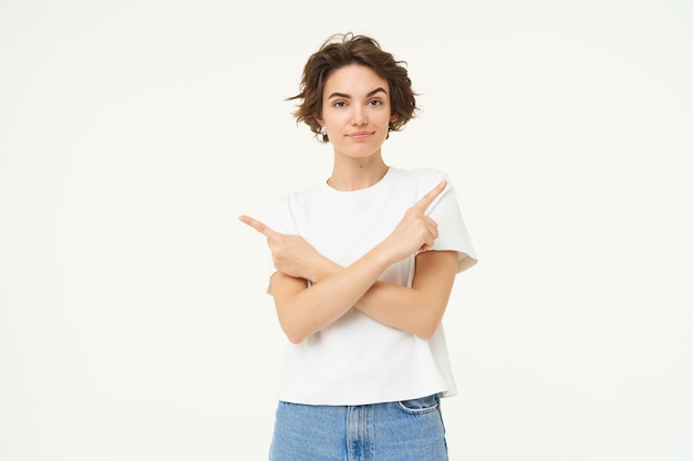 Photo gratuite une femme perplexe fait un choix, pointe les doigts à gauche et à droite en décidant confuse de ce qu'il faut choisir