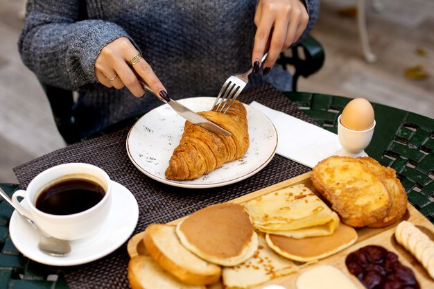 Femme, petit déjeuner, croissant, café