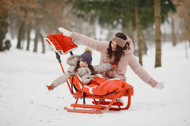 Photo gratuite femme et petite fille dans un parc avec traîneau