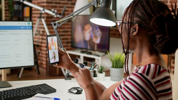 Femme pigiste parlant aux gens lors d'un appel vidéo de cours de webinaire, utilisant la vidéoconférence de classe en ligne pour discuter avec des collègues. Jeune adulte participant à une téléconférence, distance sociale.