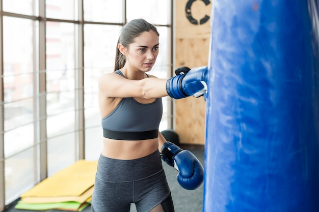 Femme pincer le sac dans la salle de gym