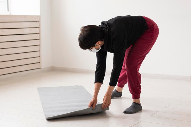 Femme plaçant un tapis de fitness sur le sol