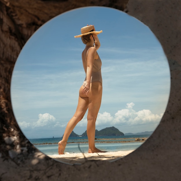 Photo gratuite femme à la plage en été posant avec miroir rond