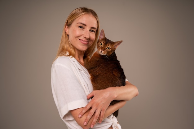 Photo gratuite femme de plan moyen avec chat en studio