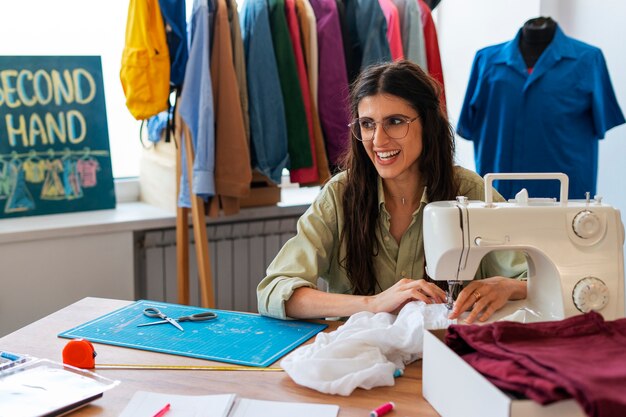 Femme de plan moyen travaillant dans un magasin de revente