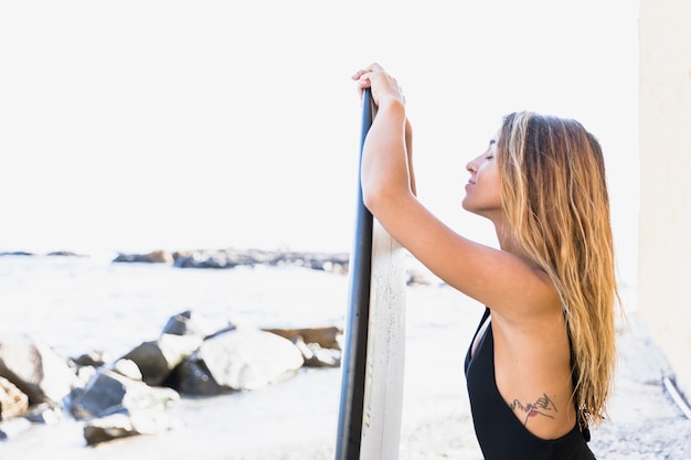 Photo gratuite femme avec planche de surf à la plage