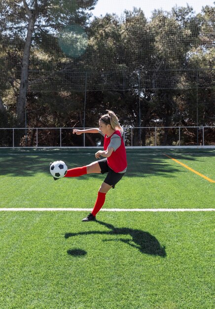 Femme de plein air jouant au football