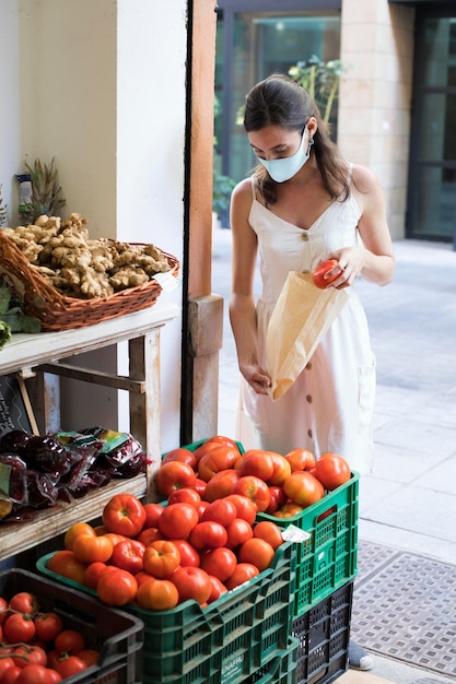 Femme plein coup achetant des légumes