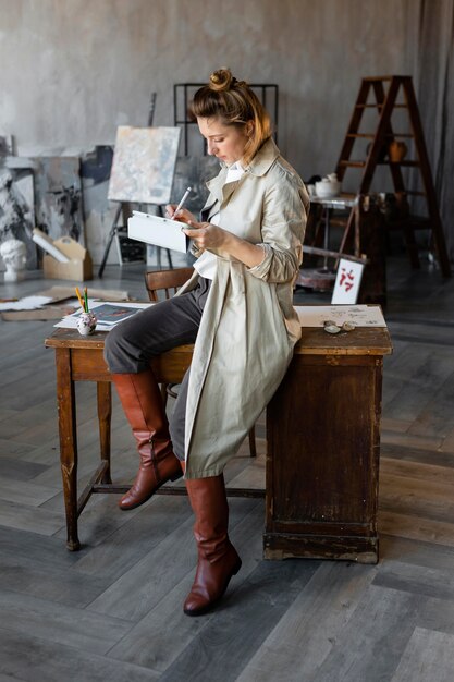 Femme plein coup sur chaise avec tablette