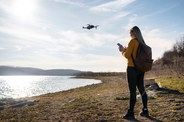 Femme plein coup avec drone à l'extérieur