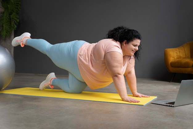 Femme de plein coup exerçant au gymnase