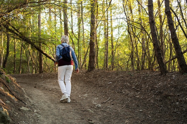 Photo gratuite femme plein coup marchant dans la forêt