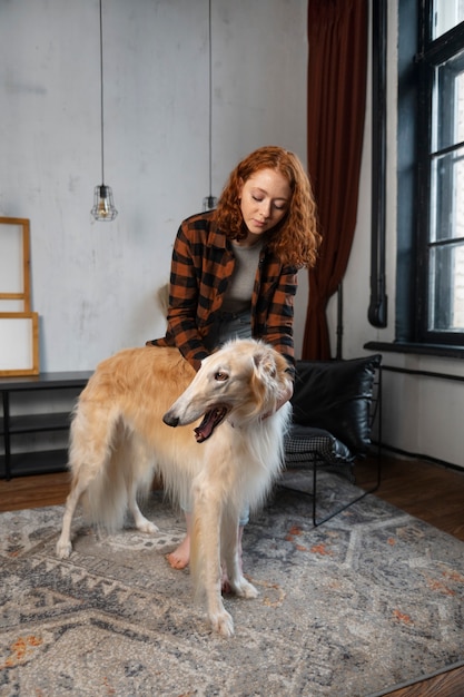 Femme plein coup avec un mignon chien lévrier