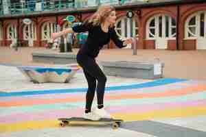 Photo gratuite femme plein coup avec planche à roulettes