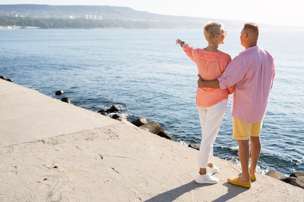 Femme plein coup pointant vers la mer