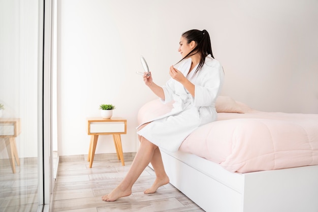 Femme plein coup à la recherche dans le miroir