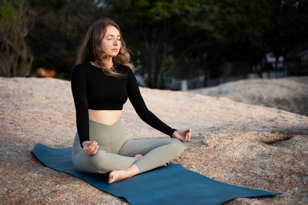 Femme plein coup sur tapis de yoga