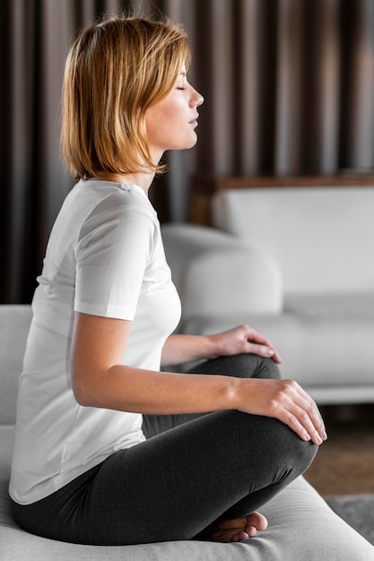 Femme pleine assise sur le canapé