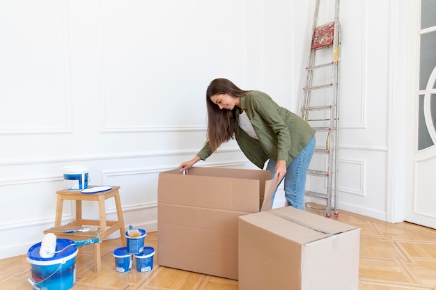 Photo gratuite femme pleine coup ouvrant la boîte à la maison