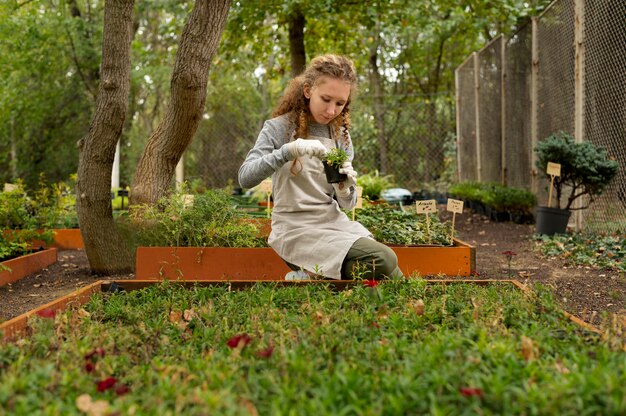 Femme pleine coup tenant un pot de plante