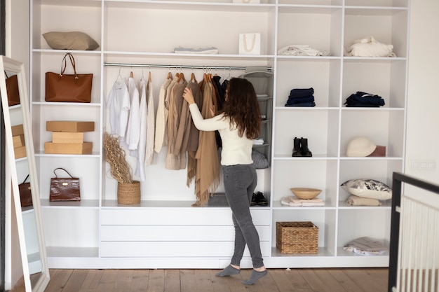 Femme pleine de coup vérifiant la garde-robe