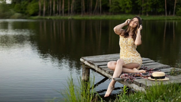 Photo gratuite femme pleine de coups avec des écouteurs à l'extérieur