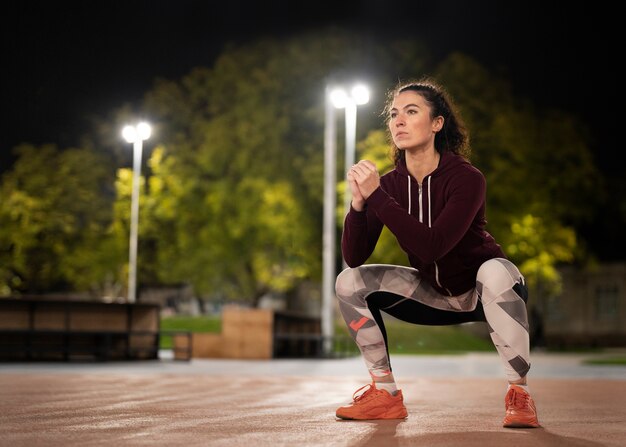 Femme pleine de coups faisant des squats