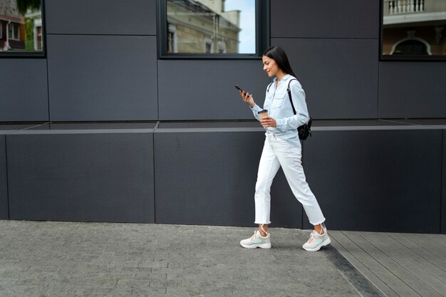 Femme pleine de coups marchant avec un appareil