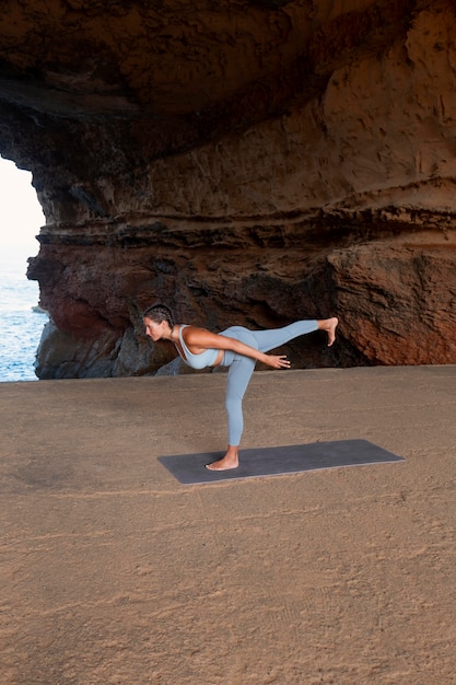 Femme en pleine forme faisant du yoga au bord de la mer