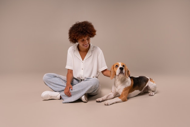 Photo gratuite femme pleine photo avec chien en studio