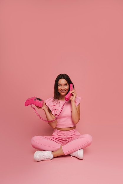 Une femme en pleine photo posant avec une tenue rose