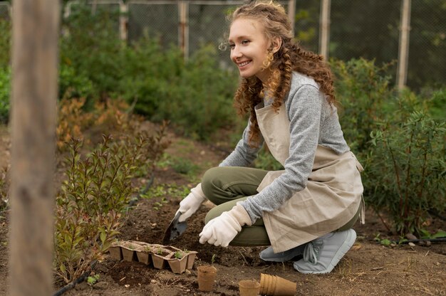 Femme pleine de plantes cultivant des plantes