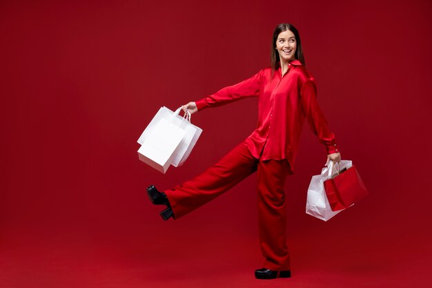 Femme pleine de smiley tenant des sacs à provisions