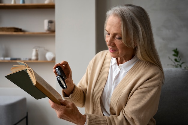 Femme plus âgée à l'aide d'une loupe pour lire