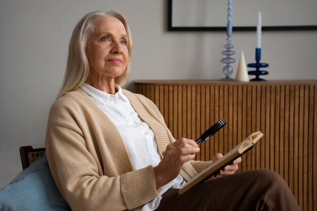 Femme plus âgée à l'aide d'une loupe pour lire