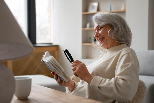 Femme plus âgée à l'aide d'une loupe pour lire